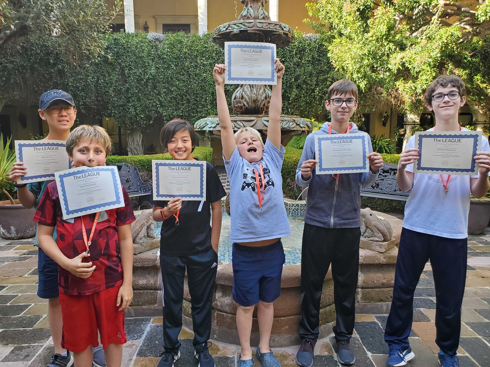 Students holding up their completion certificates