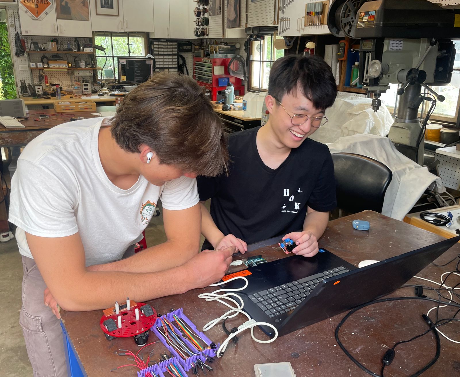 Two students at a workbench in the Robot Garage, building a robot