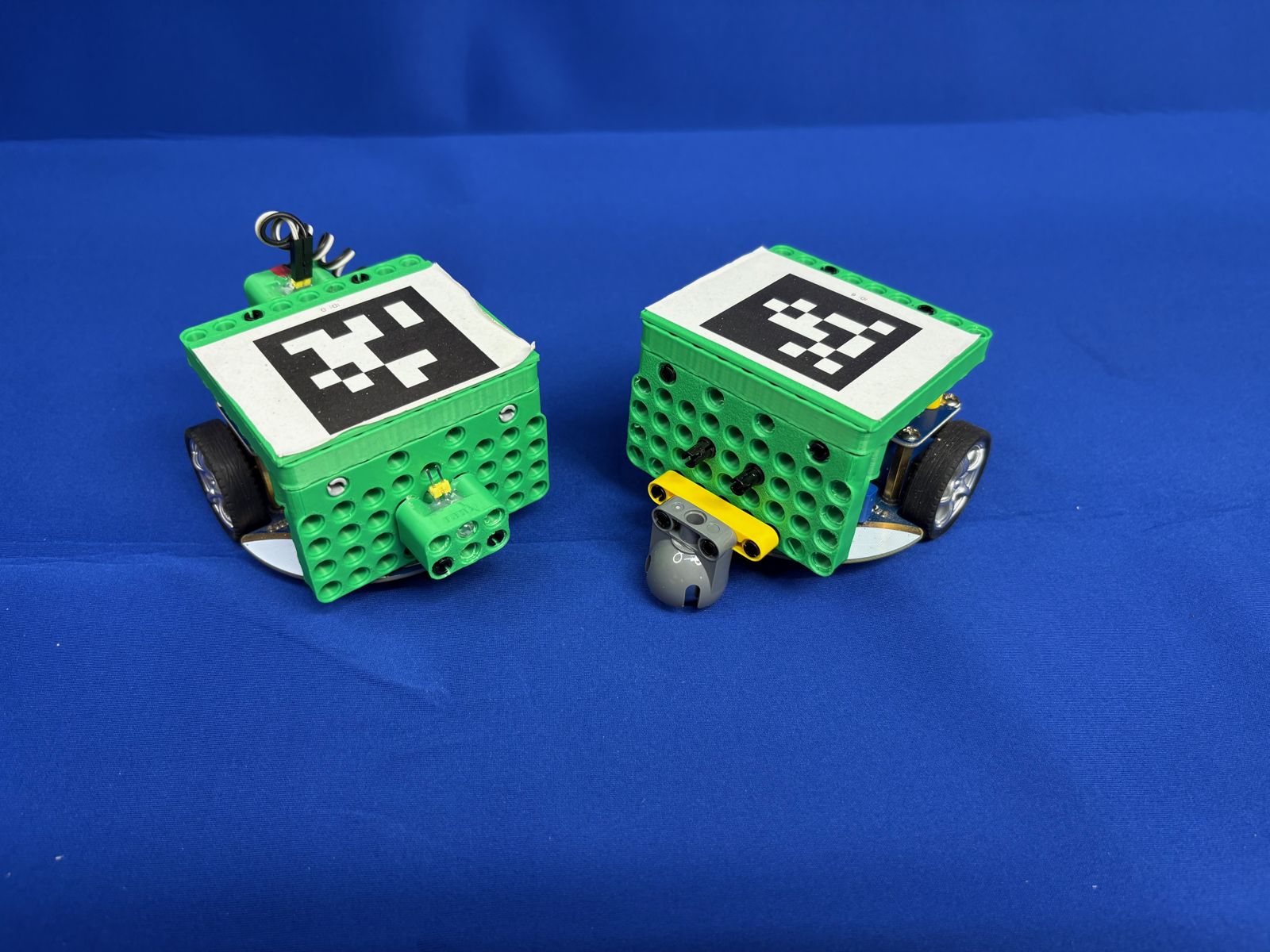 Two small robots on a blue surface
